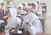 Anak anak menikmati makan bergizi gratis