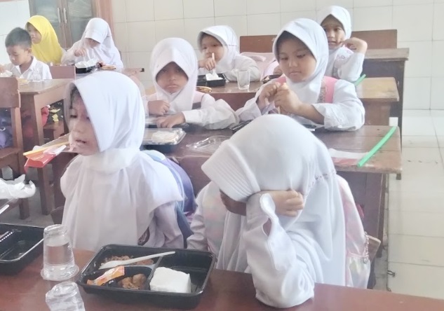 Anak anak menikmati makan bergizi gratis