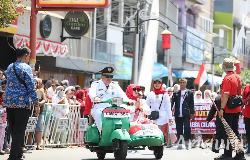 BONCENGAN: Camat Babakancikao membocengkan istrinya menggunakan vespa di karnaval kemerdekaaan.