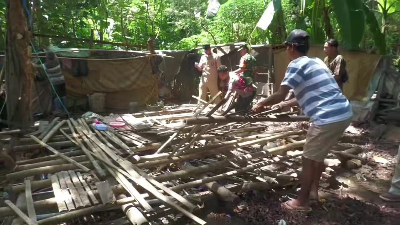ROBOHKAN GUBUK: Sejumlah warga sedang merobohkan gubuk yang ditinggali oleh keluarga Mang Ujang di Desa Jatimekar, Kecamatan Jatiluhur.