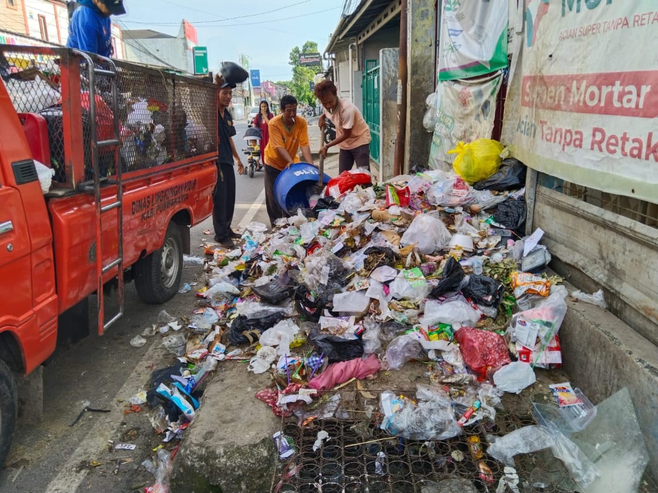 BERSIHKAN SAMPAH: Petugas DLH Kabupaten Purwakarta sedang membersihkan sampah di wilayah perkotaan.