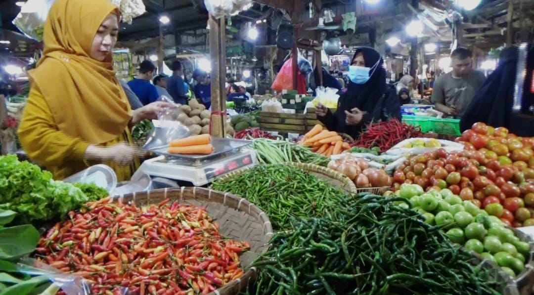 PEDAGANG SAYUR: Pedagang sayur di Pasar Rebo Purwakarta sedang melayani pembeli. Kini harga sayur di wilayah Purwakarta kembali melonjak.