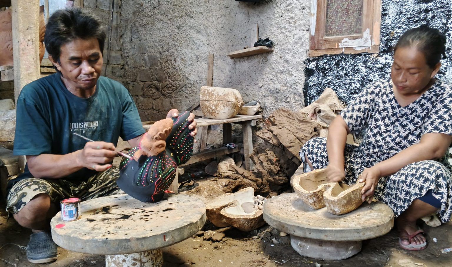 CELENGAN: Pengrajin gerabah sedang membuat celengan berbentuk ayam jago di Plered.