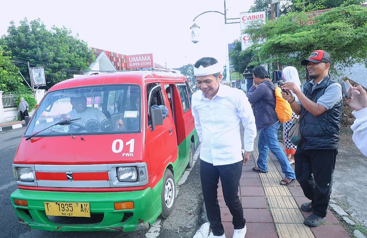 ANGKUTAN UMUM: Bupati Purwakarta Saepul Bahri Binzein saat turun dari angkot.