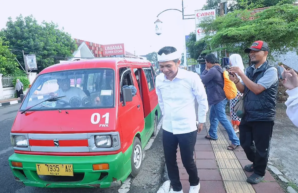 ANGKUTAN UMUM: Bupati Purwakarta Saepul Bahri Binzein saat turun dari angkot.